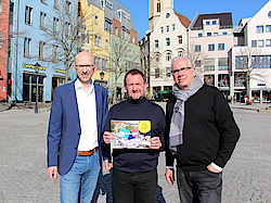 Drei Herren präsentieren vor dem Jenaer Marktplatz den Flyer zum jobwalk Jena.
